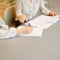 Zwei Personen sprechen Dokumente am Tisch durch